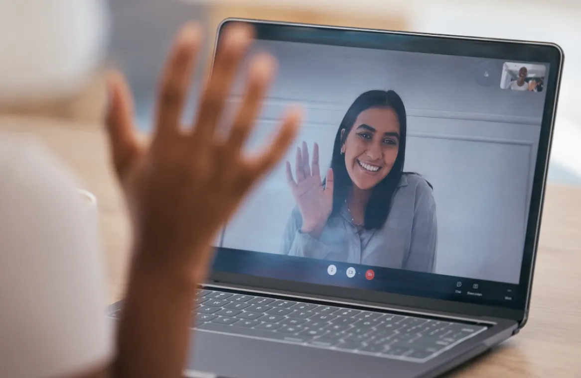 Person waving at an online meeting
